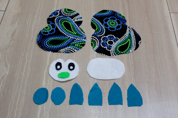 fabric pieces cut out for a cute stuffed penguin from free pattern