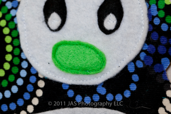 straight stitch applique of nose on stuffed penguin