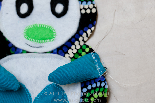 arm stitched onto stuffed penguin